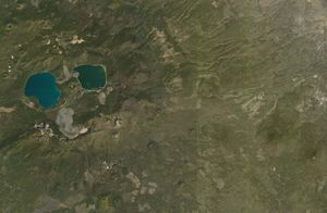 Satellite imagery of two lakes amidst a sea of pines